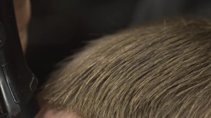 理发师将伤口的末端标记为退化的，现在在客户的额头上，剃成直线