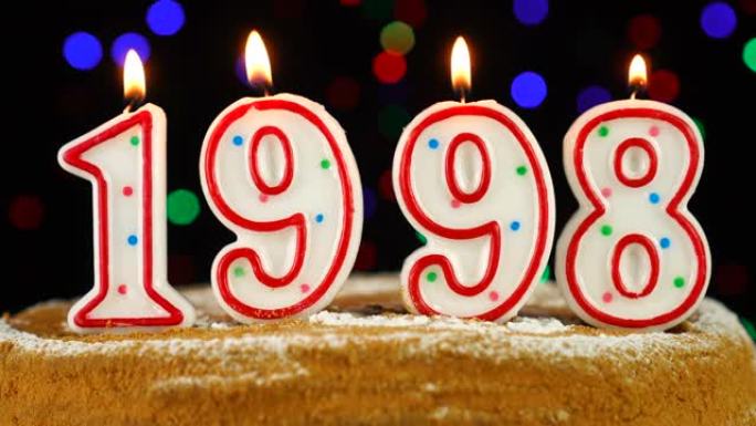 生日蛋糕与白色燃烧的蜡烛在数字1998的形式