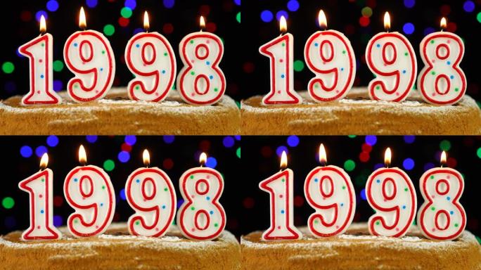 生日蛋糕与白色燃烧的蜡烛在数字1998的形式