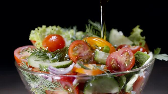 新鲜蔬菜沙拉在黑色背景的玻璃碗中倒入橄榄油。黑魔法Ursa Pro G2，4K，150 fps。