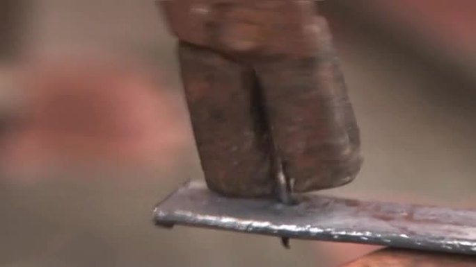 铁匠试图用钳子去除生锈的铁钉1