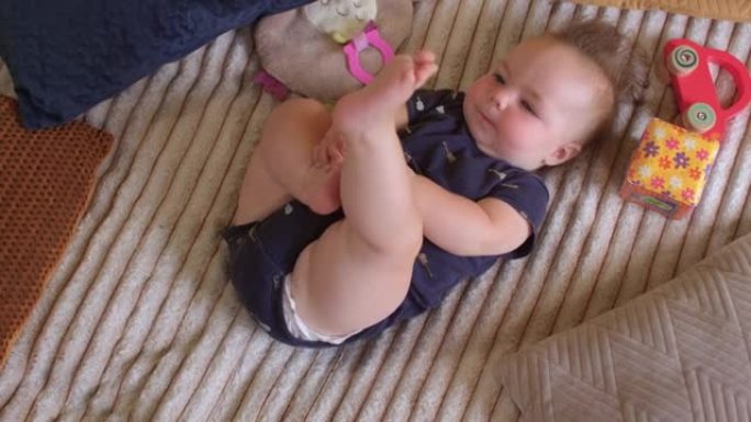 六个月大的婴儿把脚放进嘴里。良好的肌张力弯曲连枷肢。