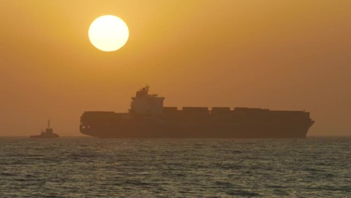 夕阳西下时，一个巨大的集装箱在海上移动，这是一个令人惊叹的长镜头