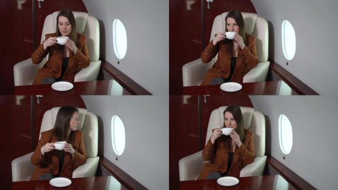 飞机客舱头等舱的女人喝咖啡。私人飞机豪华旅行中的乘客vip
