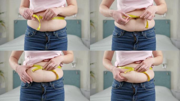 年轻女子想减肥用卷尺测量她的腰部。节食的概念，不健康的生活方式，超重和肥胖