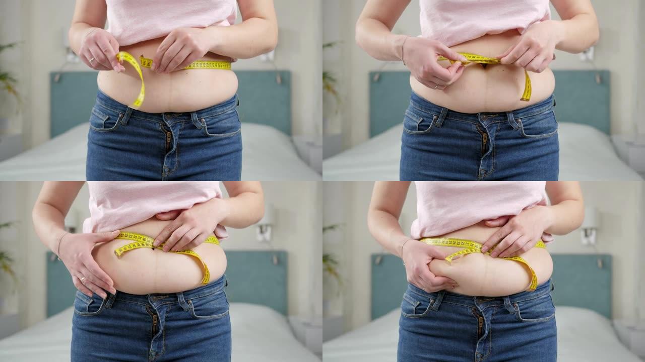 年轻女子想减肥用卷尺测量她的腰部。节食的概念，不健康的生活方式，超重和肥胖