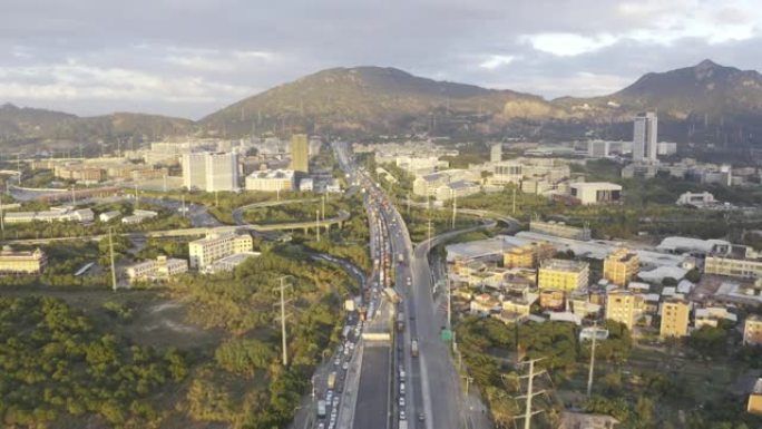 夕阳下的城市建筑物和干道上拥挤的交通流量