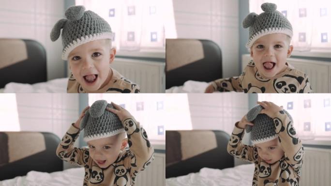可爱的小男孩嬉戏做鬼脸看着相机的肖像玩得开心淘气的孩子享受快乐孩子4k的有趣表情。戴着可爱的兔子帽