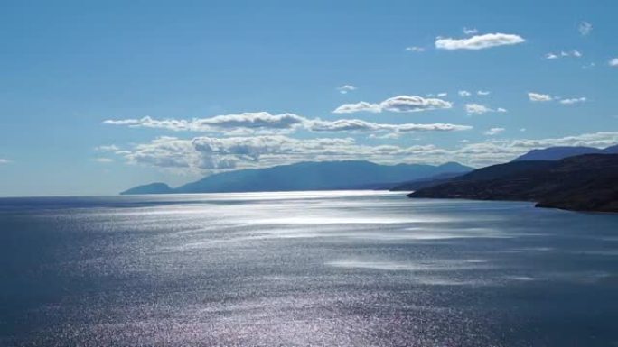 从海边高处流逝。美丽的自然景观。风推动海浪沿着海面。大海闪烁着银色，闪烁着火花。夏季背景与复制空间