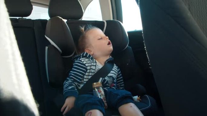旅行期间，蹒跚学步的女孩睡在车内的背部