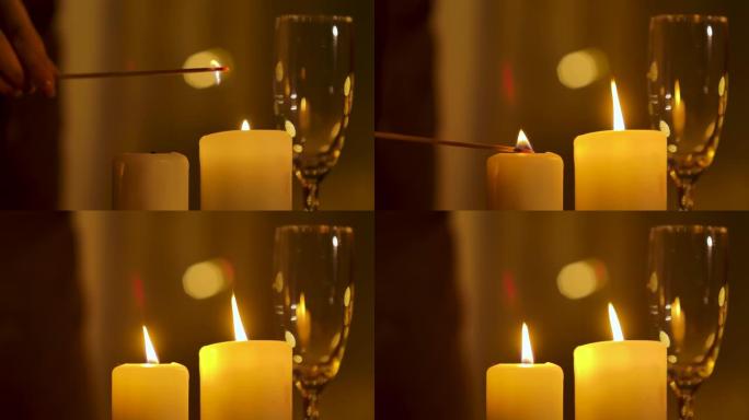 女人手灯蜡烛站在节日的桌子上。准备庆祝圣诞节或新年。灯光和香槟杯背景模糊。光线不足。关闭内部细节。慢
