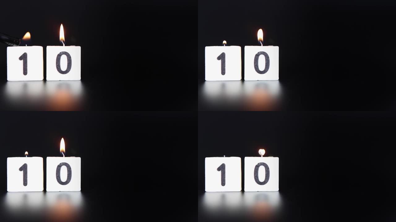一根方形蜡烛，上面写着数字10被点燃并吹出，庆祝生日或周年纪念日。