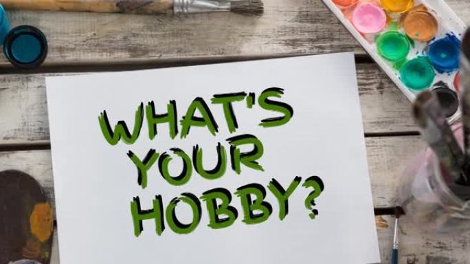 动画什么是你的爱好的文字在绿色，与水彩画和画笔在桌面上