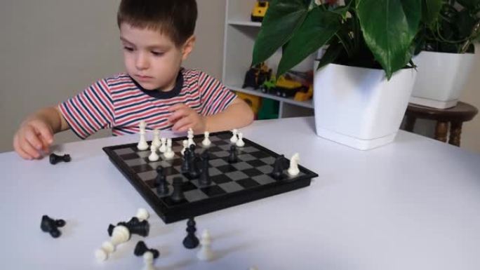 一个4岁的男孩下棋，沉迷并在桌子上巡回演出