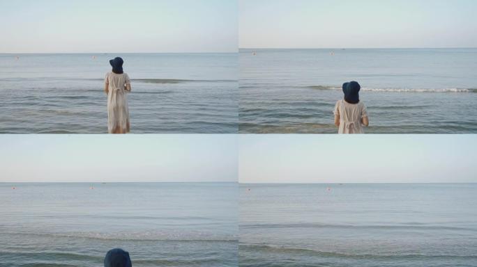 亚洲孕妇在沙滩上散步