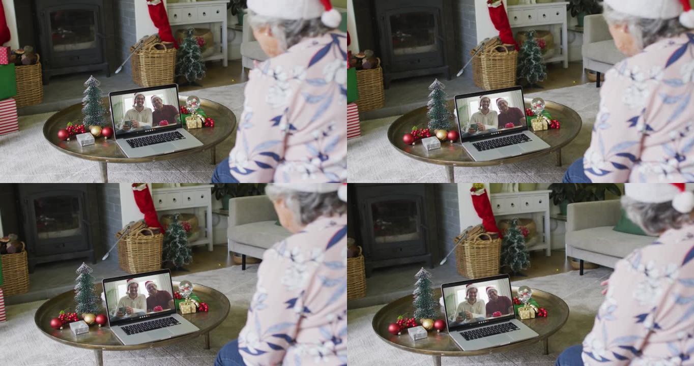 白人高级妇女使用笔记本电脑进行圣诞节视频通话，屏幕上有微笑的家人