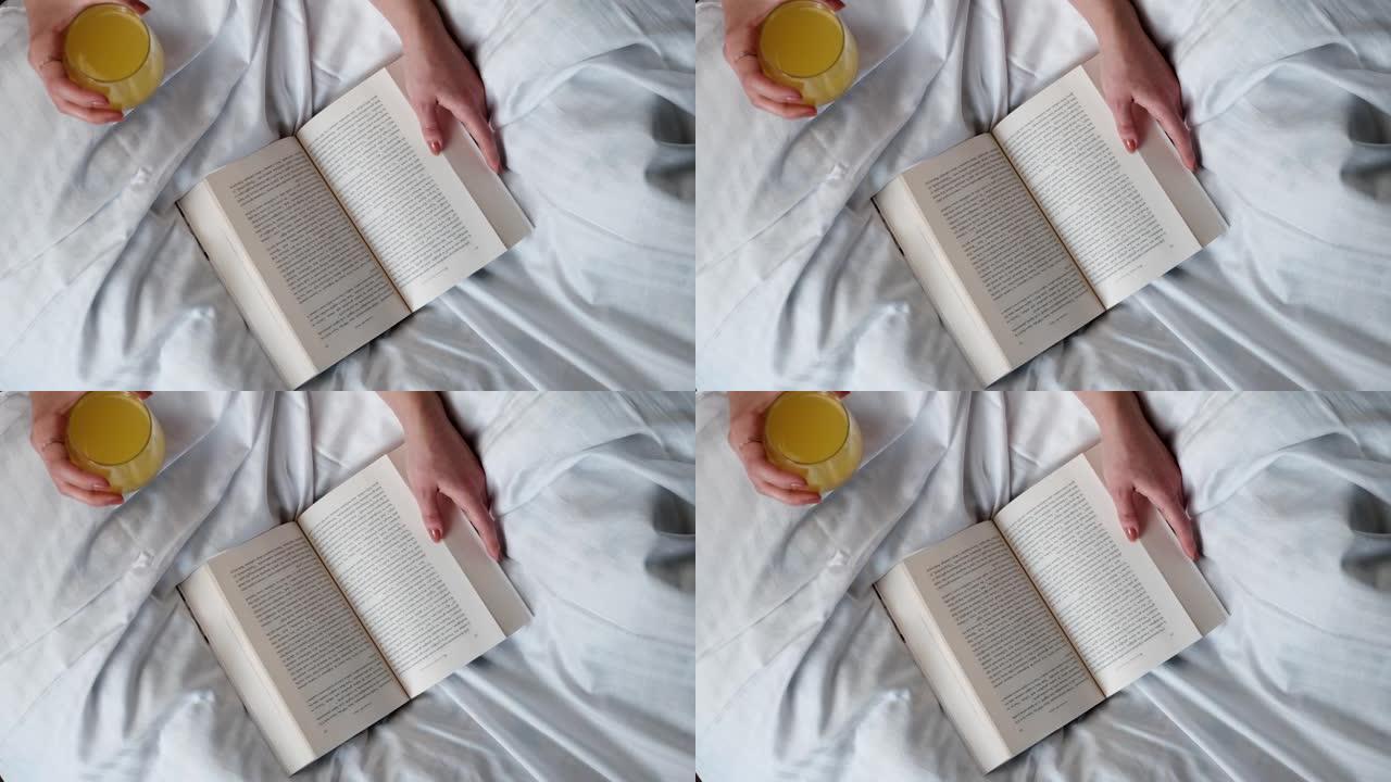 女人在白色床上喝天然果汁用手翻书