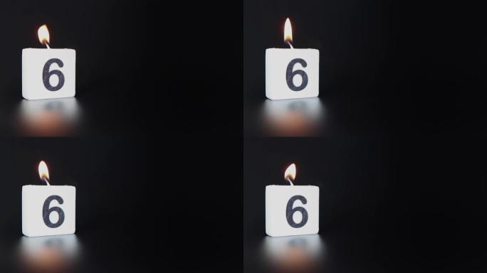 一根方形蜡烛，上面写着数字6被点燃并吹出，庆祝生日或周年纪念日。