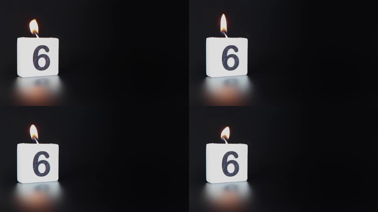 一根方形蜡烛，上面写着数字6被点燃并吹出，庆祝生日或周年纪念日。