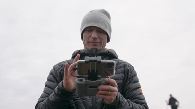 摄影师使用遥控手机控制无人机