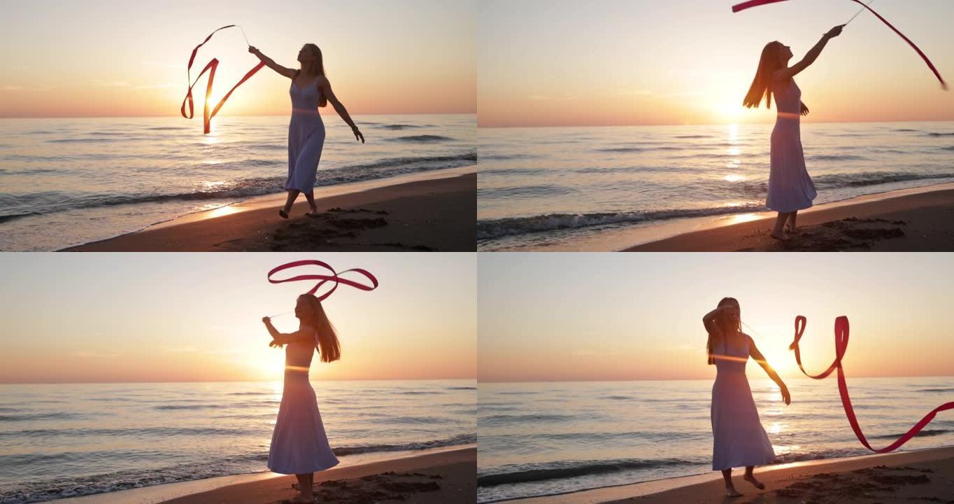 十几岁的女孩在海滩上用丝带跳舞。