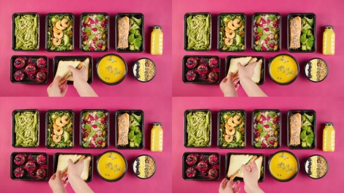 送餐俯视图，用一次性容器带走餐点。午餐盒的特写镜头，粉红色背景上有煮熟的素食菜肴。健康饮食。餐饮服务