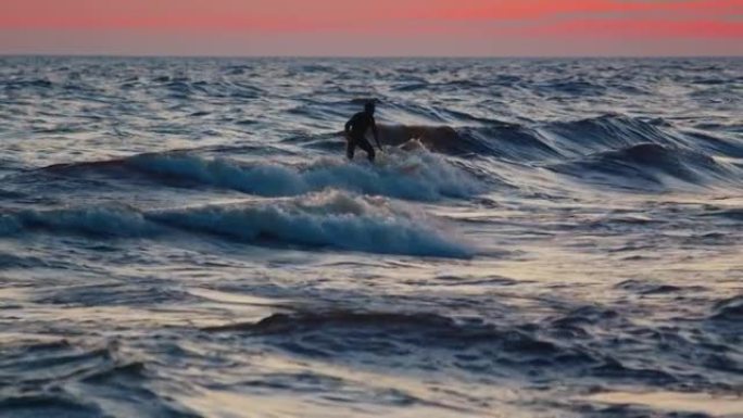 俄罗斯冲浪故障。身穿黑色潜水服的男子试图在俄罗斯拉多加湖上赶上风浪，并在尝试失败后愤怒地打手势
