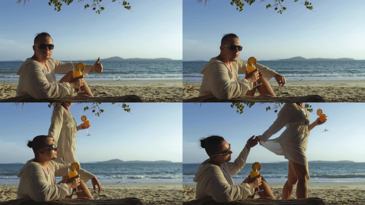 穿着白色连衣裙的男人在海滩上喝菠萝鸡尾酒Pina Colada。概念休憩之海，热带度假旅游，暑假