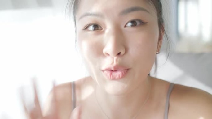 分享经验。穿着运动服的美丽年轻亚洲女性在家里客厅制作社交媒体视频