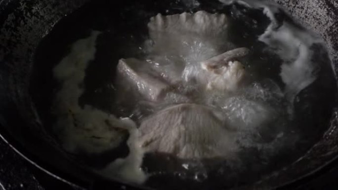 猪肉块在平底锅上的沸水中煮沸