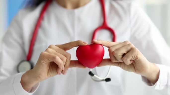 医生心脏病专家在诊所拿着红色玩具心脏特写4k电影慢动作