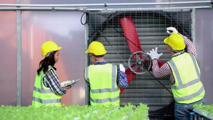 工厂工人技术员工程师男女在带有工作服和头盔的机器涡轮机上展示和检查系统。概念安装建筑和维修重型工业机