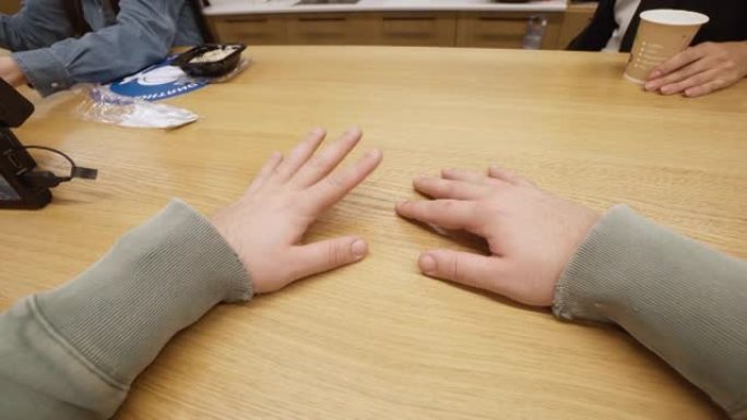 男性双手放在桌子上，手指在敲门