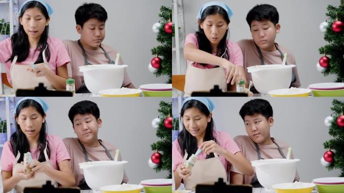 亚洲儿童在圣诞节期间在家拍摄烹饪饼干视频，以获取病毒视频或在家一起拍摄TikTok，这是新一代概念的