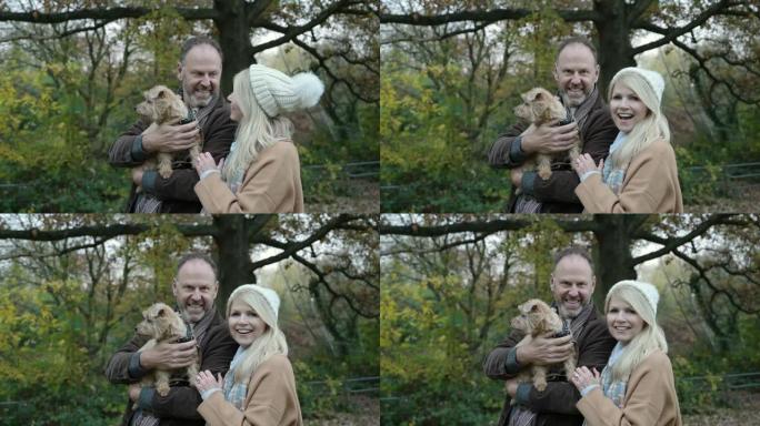 林地公园成熟夫妇和狗的季节性肖像