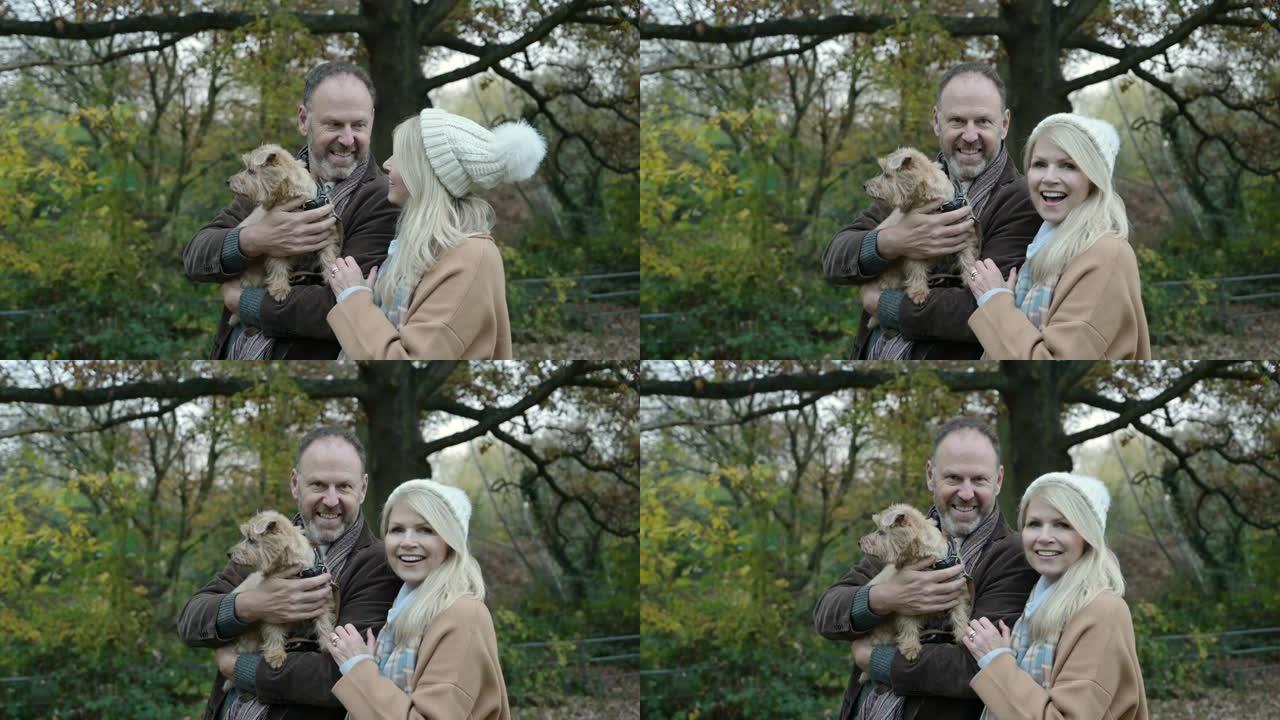 林地公园成熟夫妇和狗的季节性肖像