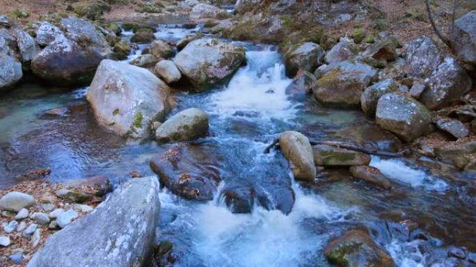 一条纯净的河流在河流的大石头之间流动