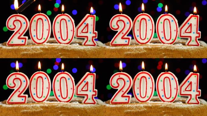 生日蛋糕与白色燃烧的蜡烛在数字2004的形式
