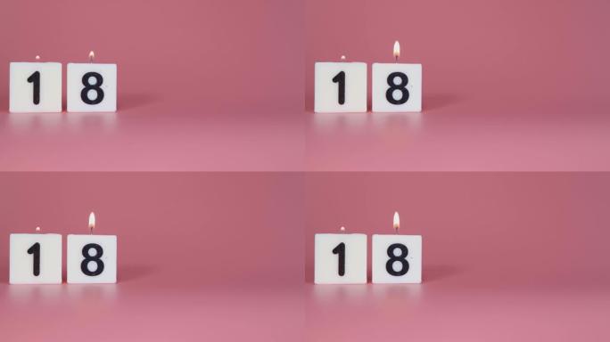 一根方形蜡烛，上面写着数字18在庆祝生日或周年纪念日的粉红色背景上被点燃和吹灭