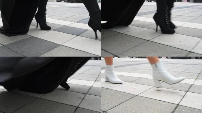 穿着黑白鞋子的模特的女性腿沿着瓷砖城市道路在城市中行走。