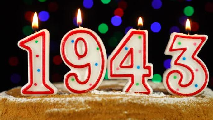 生日蛋糕与白色燃烧的蜡烛在数字1943的形式