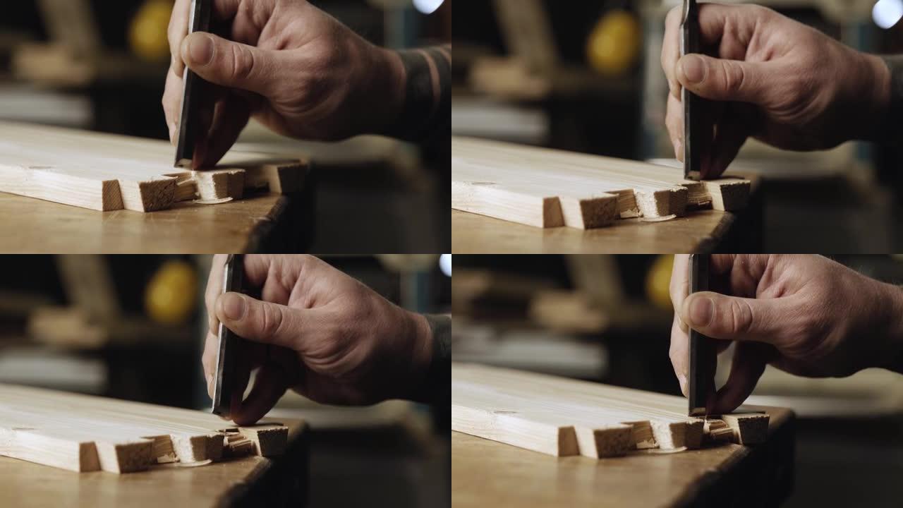 特写。木工用凿子在松木板上切出燕尾榫。燕尾榫细木工是用手工工具完成的。木工制作燕尾榫