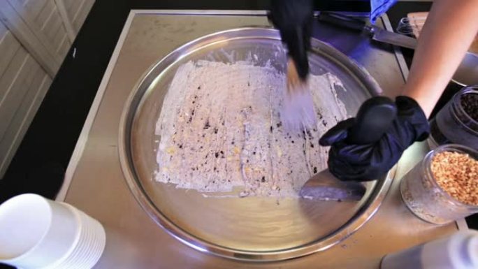 身份不明的厨师正在泰国夏季在冷盘上制作天然美味的巧克力香蕉冰淇淋卷