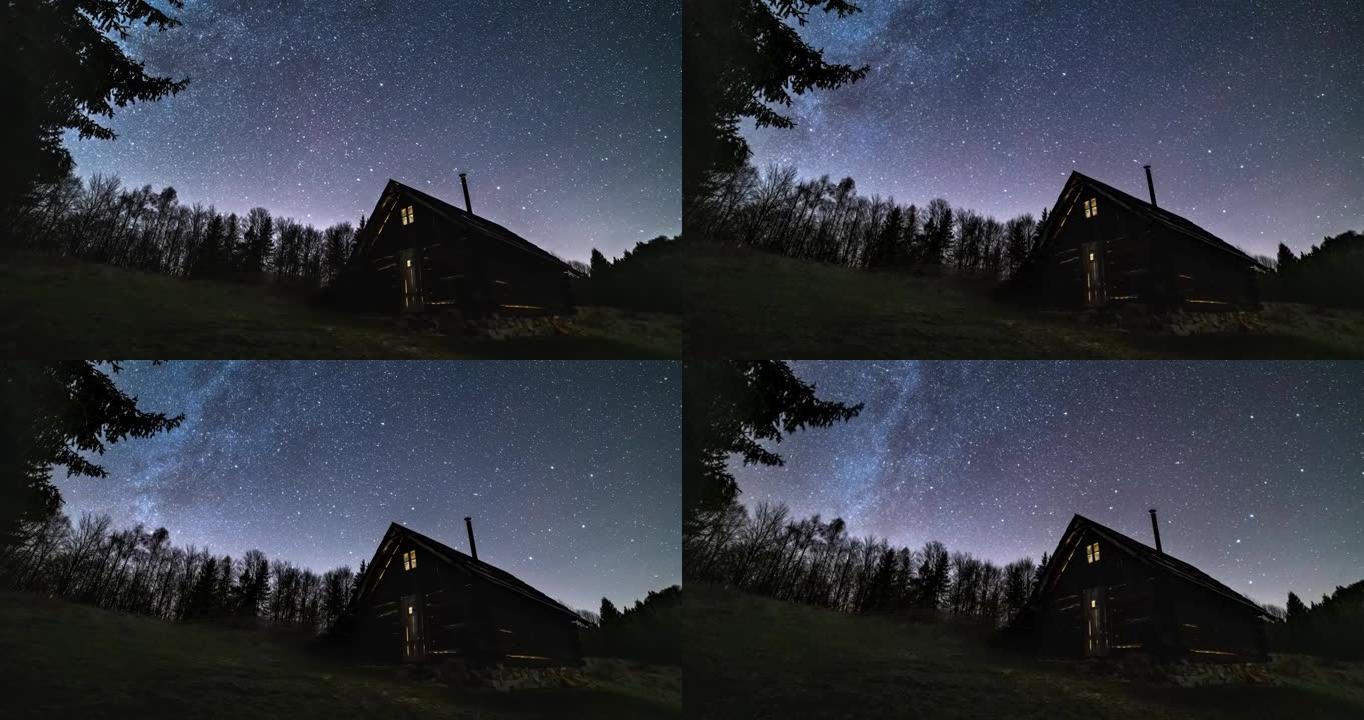 浪漫的星空和银河系在野生森林自然天文学延时4k的老木屋上快速旋转