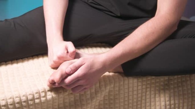 高加索男性按摩师为自己做自我按摩腓肠肌肌肉和踝关节的肌痉挛释放。健康改善班的自我管理