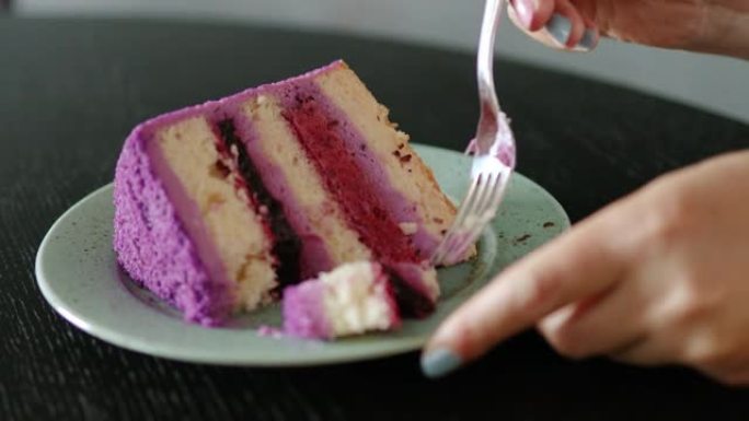 特写镜头用叉子打碎一块水果浆果蛋糕。带蛋糕和黑咖啡的咖啡休息时间