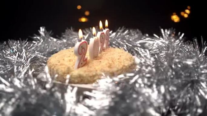 圣诞蛋糕装饰着燃烧的蜡烛在新年2022的形式。