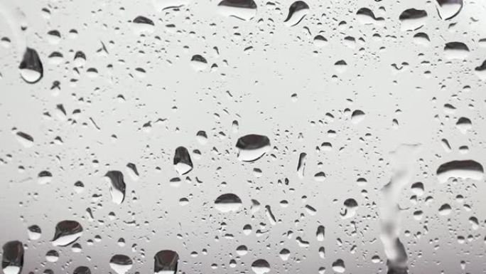 玻璃上水滴的特写。透明清晰的大雨背景。雨滴溅到窗户上。在玻璃表面上滴水。
