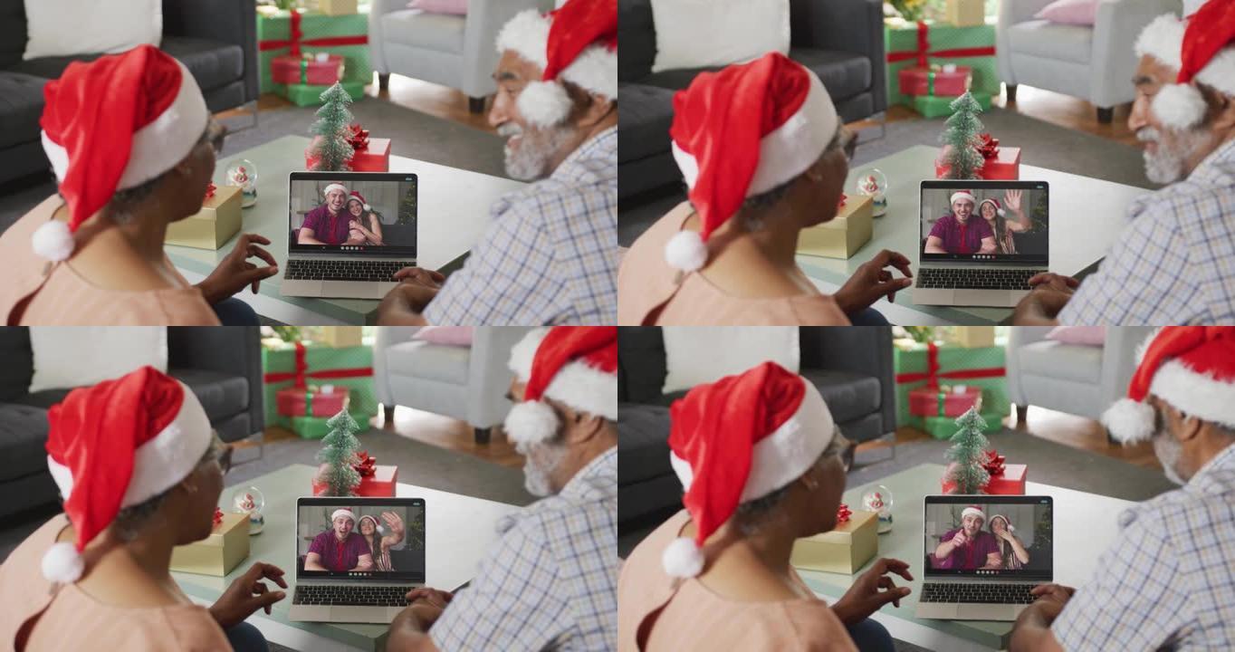 快乐的高级非洲裔美国夫妇在圣诞节期间在笔记本电脑高加索夫妇上进行视频通话