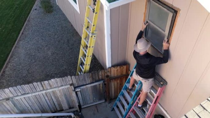2名成人拆除了他们房子2楼的旧窗户4k无人机住宅库存视频